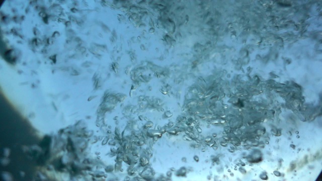 潜入水中。以慢动作落入水中。不同大小的泡沫在泡沫的绿松石水。下沉。版本3。视频素材