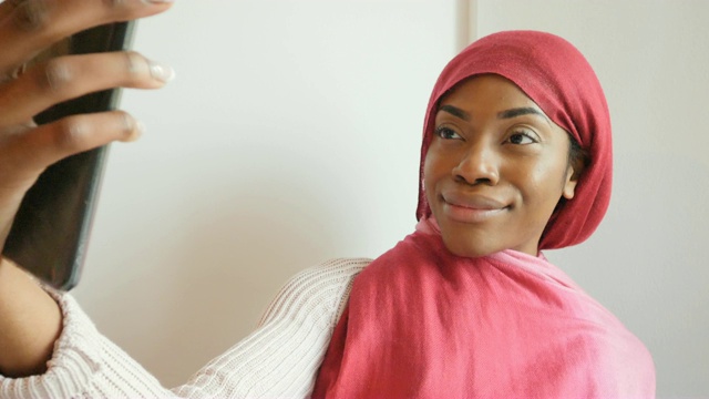 一位戴着粉色头巾的阿拉伯黑人妇女在自拍视频下载