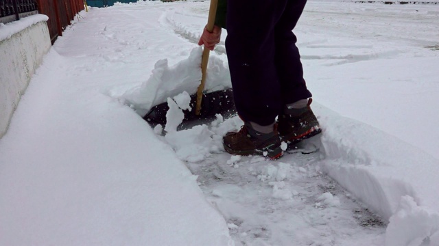 冬天，人们用雪铲清扫人行道视频素材
