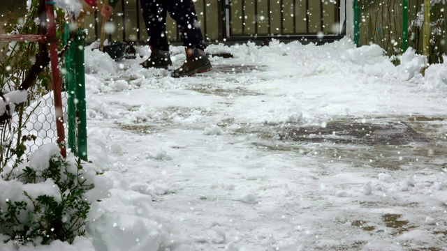 冬天，人们用雪铲清扫人行道视频素材