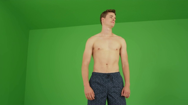 快乐的白人穿着游泳短裤站在绿色屏幕上放松视频素材