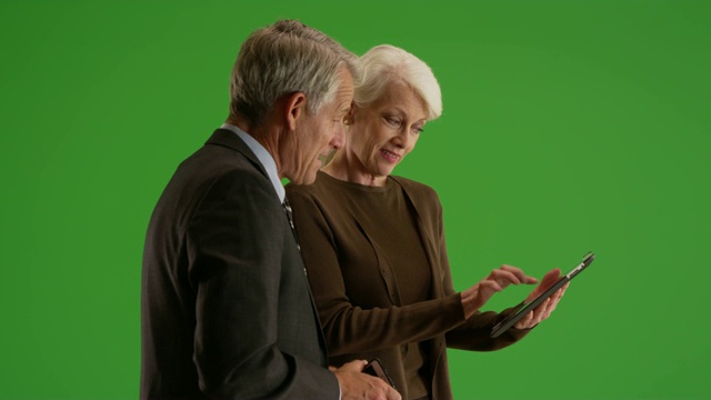 高级业务团队在办公室用绿色屏幕的平板电脑工作视频素材