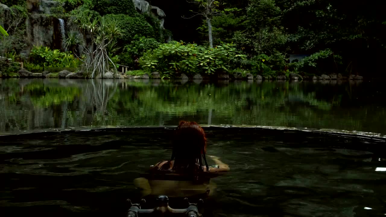 在丛林里泡热水澡。在温泉疗养地放松的女人视频下载