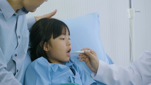 女医生在测量体温后看着体温计。女孩正在接受健康专业医生的检查。视频素材