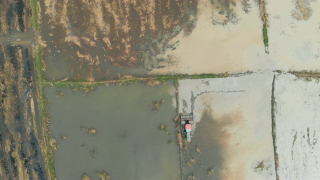 无人机拍摄的鸟瞰图是拖拉机正在铲地的稻田农场视频素材