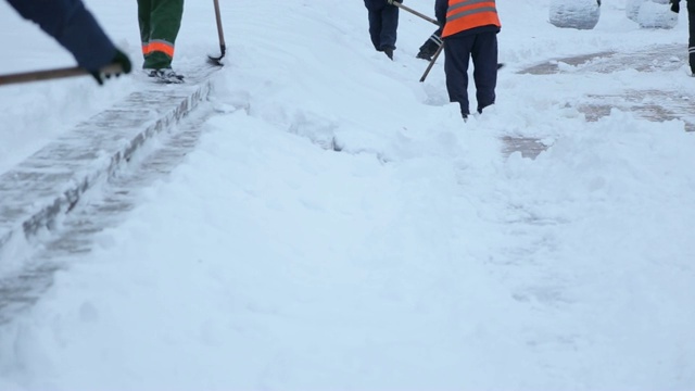 工人在冬天清扫道路上的积雪，清理道路免受暴风雪。视频素材