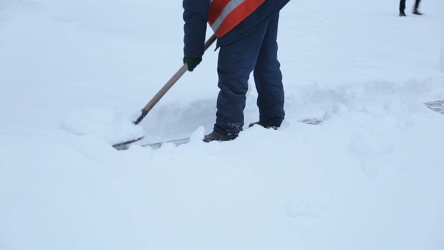 工人在冬天清扫道路上的积雪，清理道路免受暴风雪。视频素材