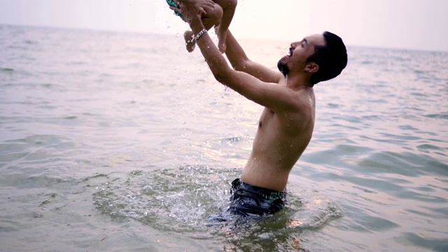 父亲和女儿一起在海边玩日落。视频素材