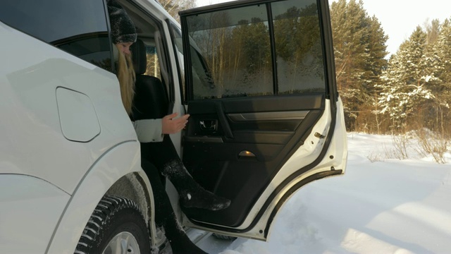 一名年轻女子坐在车里清理冬天在公园散步后留下的积雪视频下载