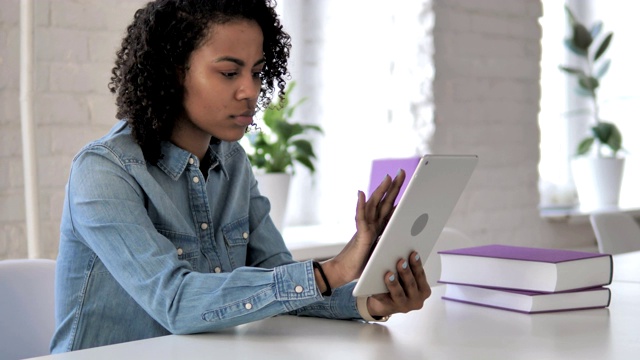 紧张的非洲女孩在使用平板电脑时对经济损失的反应视频素材
