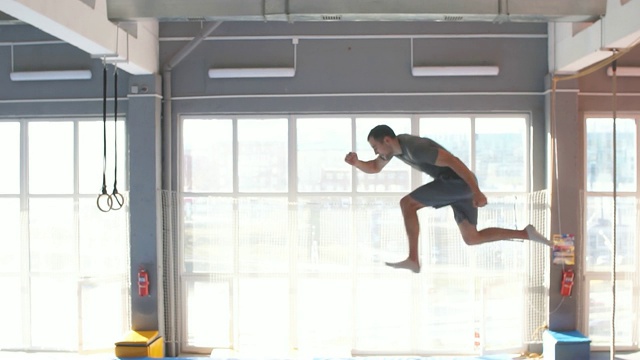 蹦床运动员在蹦床上进行复杂的杂技练习视频素材