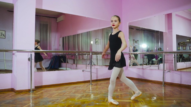 芭蕾舞女演员在工作室的镜子前跳舞。在芭蕾舞厅。视频素材