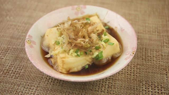 近距离观看里面有日本食物的盘子。日式传统食物放在木桌上。视频下载