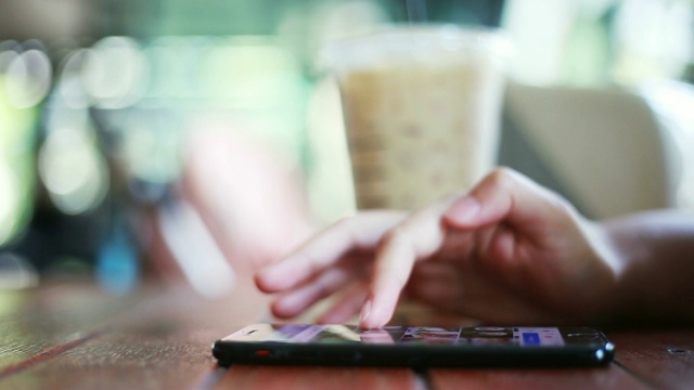 女人的手在咖啡馆里使用智能手机视频素材