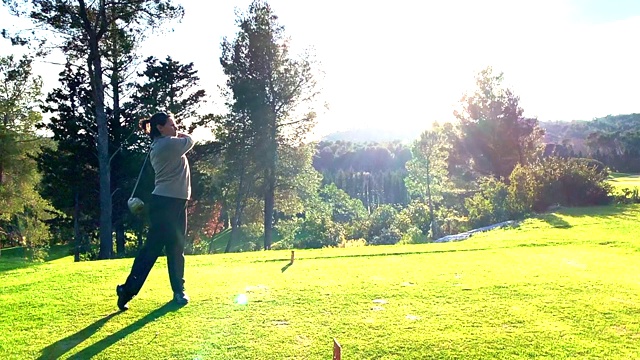 高尔夫球手与车手在高尔夫球场上对着太阳开球视频素材