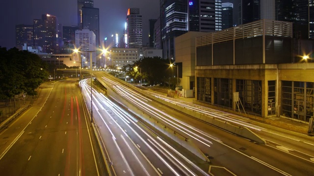 (向上倾斜)夜间的交通延时和香港摩天大楼景观。视频素材