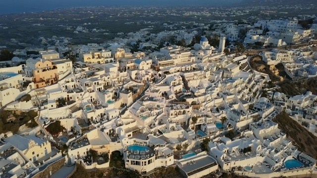 日落时分，飞越希腊圣托里尼菲拉(Thira)小镇传统的白色别墅视频下载