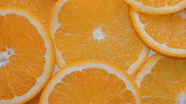 靠近切片的橘子片，旋转背景视频素材