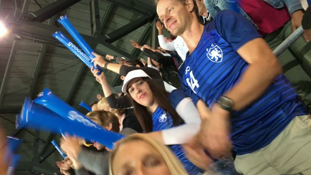 一名女子在体育场从座位上跳起来为自己的球队欢呼的智能手机视频视频素材