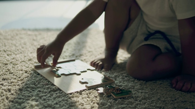亚洲婴儿在地板上玩拼图。视频素材