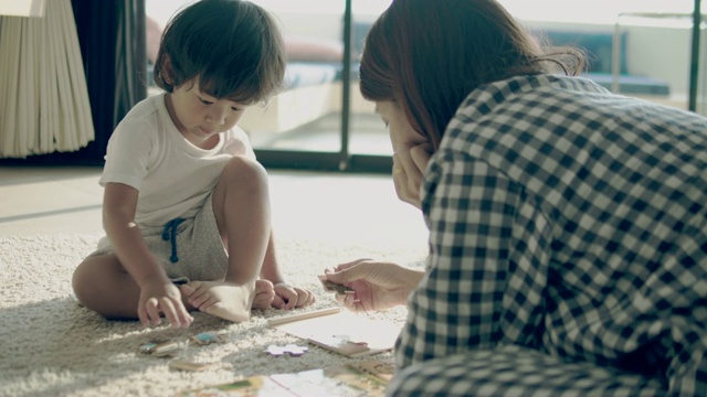 年轻的母亲和男婴在拼拼图视频素材