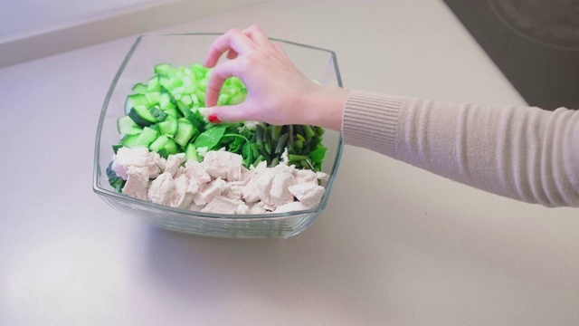 慢镜头，不明女性的手移动玻璃沙拉碗里的鸡片。素食主义的概念，自制饮食和纯素视频素材