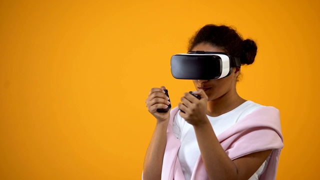 非裔美国女性戴着虚拟现实眼镜玩游戏，动作控制器视频素材