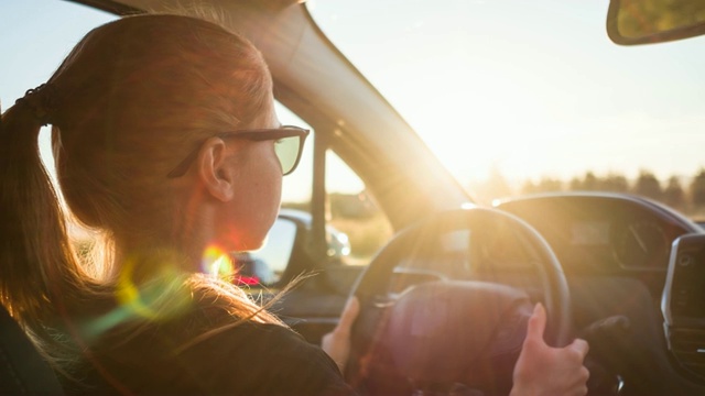 在阳光明媚的日子里，专注的女性司机在繁忙的道路上上下班视频下载