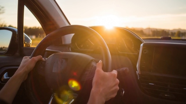 在日落时分，开车行驶在空旷的乡间小路上视频下载