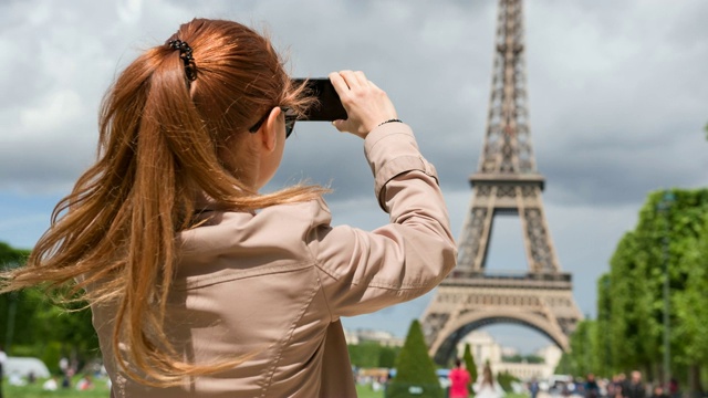 一个女人在巴黎度假，用智能手机拍摄埃菲尔铁塔视频素材