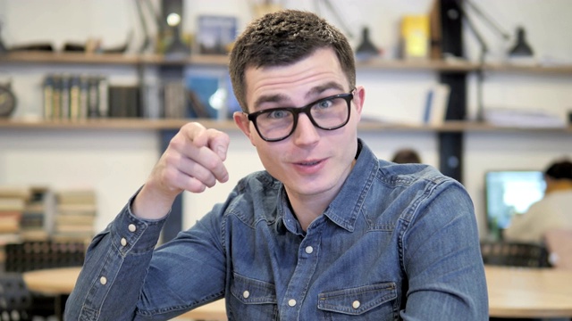 创意青年在工作中戴眼镜的邀请手势视频素材