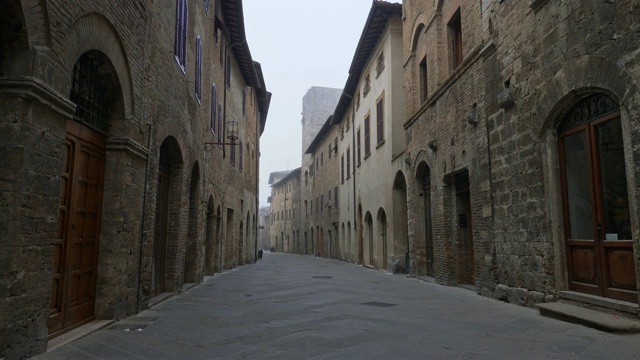 走在意大利圣吉米尼亚诺的大街上，充满了古代的气息。圣吉米尼亚诺是托斯卡纳的一个中世纪小镇。它以许多塔而闻名。4 k视频素材
