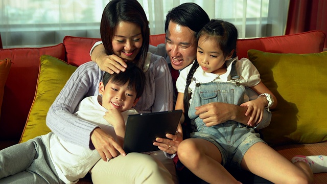 快乐的家人在客厅看平板电脑。视频素材