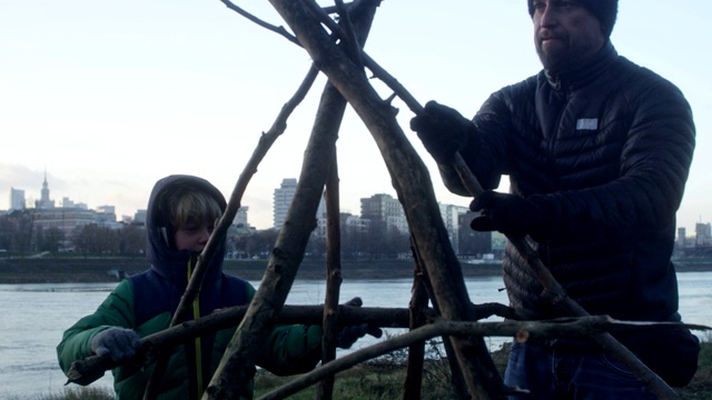 父亲和儿子们搭帐篷。城市的河滨视频下载