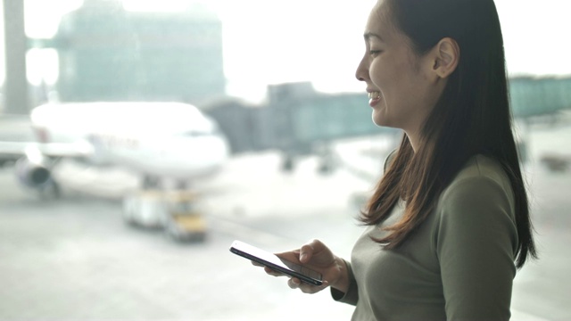 亚洲年轻女子在机场使用电话视频素材