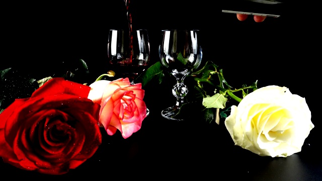 黑背景上的酒杯和玫瑰。视频下载
