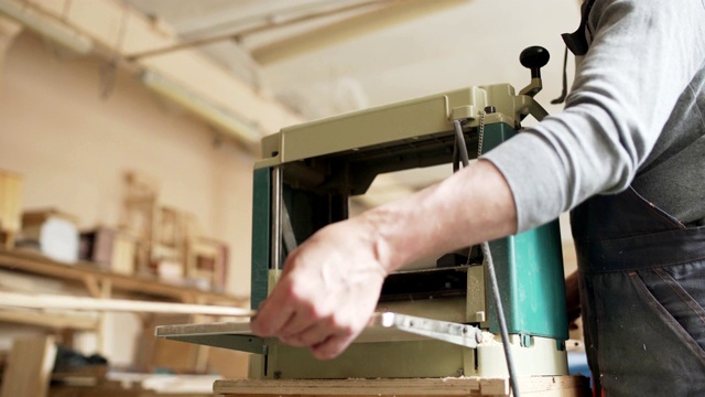 低角度熟练的木匠使用木工机器准备木板制作家具视频素材