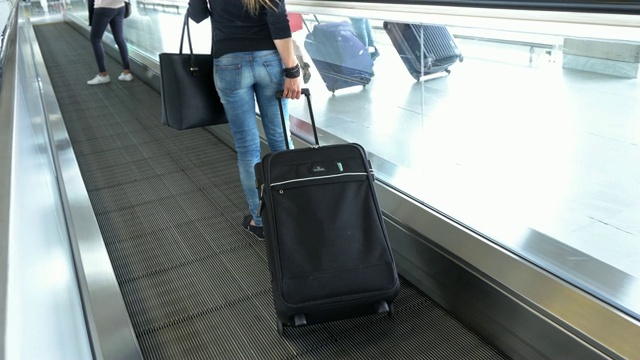 带着行李的女乘客在机场/火车站的移动人行道上旅行视频素材
