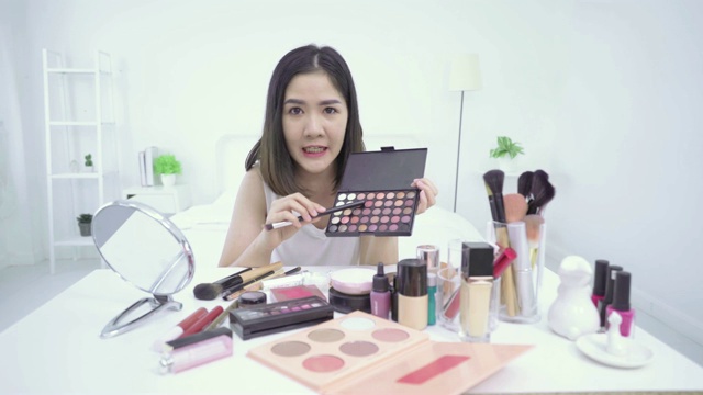 4K分辨率亚洲女性美容博主或v-logger应用口红在她的嘴做化妆品化妆教程视频素材