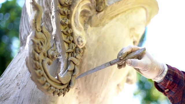 雕刻家在寺庙中制作泰国神的雕像。视频下载