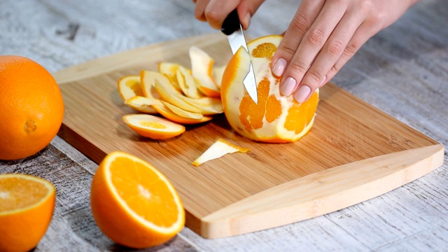 用木砧板去皮橙子。视频素材