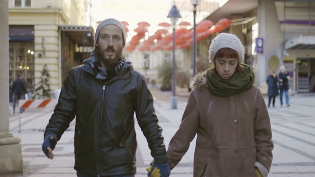 一对相爱的年轻情侣走在街上。视频素材
