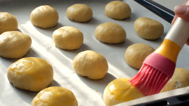 朵莉:手用刷子在生面团上刷一些蛋黄，作为烤面包前的准备工作视频下载