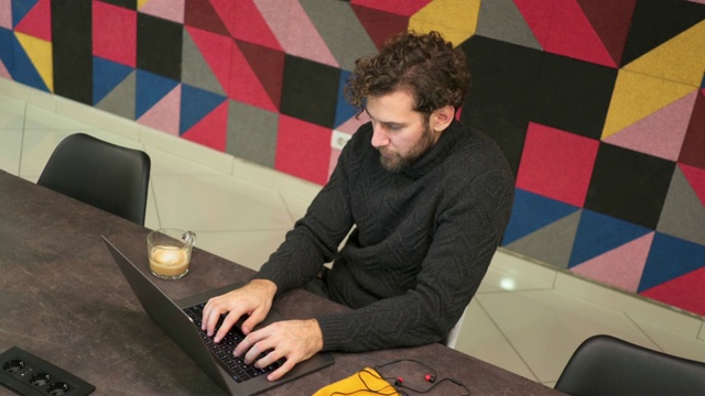 程序员一边用笔记本电脑工作，一边和同事聊天视频下载