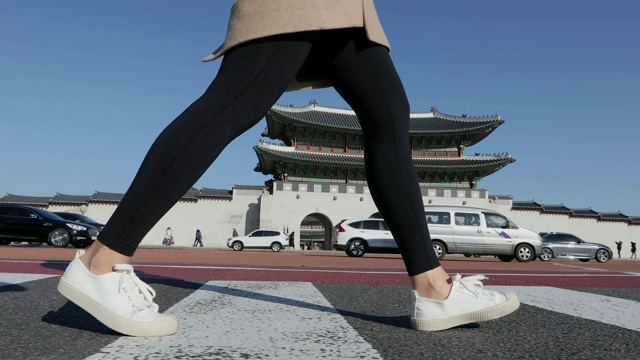 从侧面看，这名女子的腿走在光华门(景福宫入口)附近的十字路口。视频素材