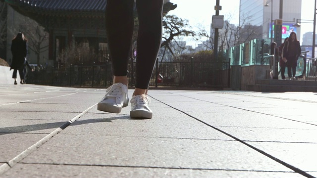 女人的鞋子和走在街道上的城市建筑视频下载