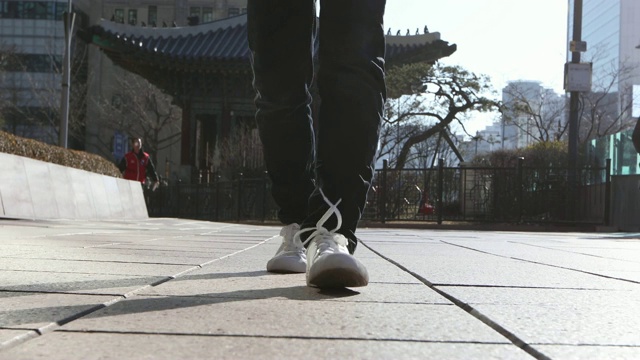 男人的腿和走在街道上的城市建筑视频素材