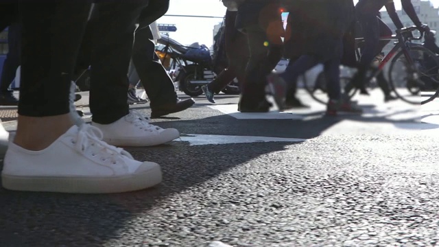 侧视图的人的腿和行走在十字路口的城市建筑视频素材