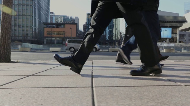 男人的鞋子和走在城市建筑的街道上视频素材