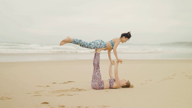 两个女人在海滩上练习acroyoga视频下载
